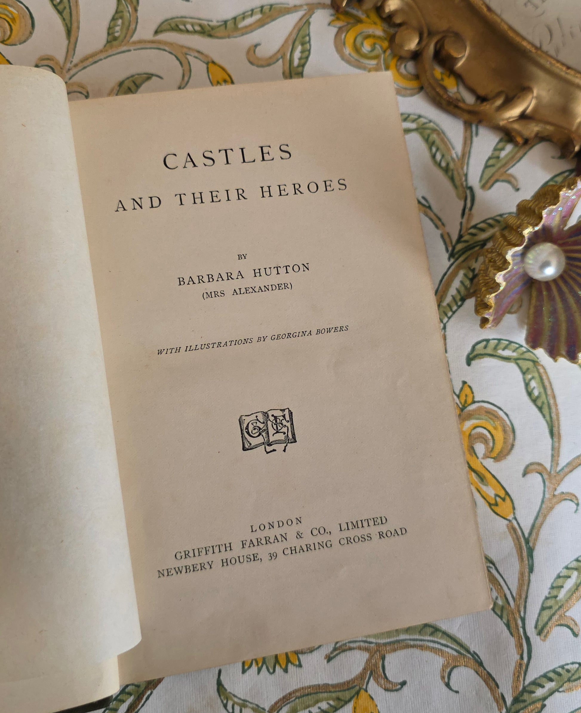 Title page of a book titled 'Castles and Their Heroes' by Barbara Hutton on a decorative background.