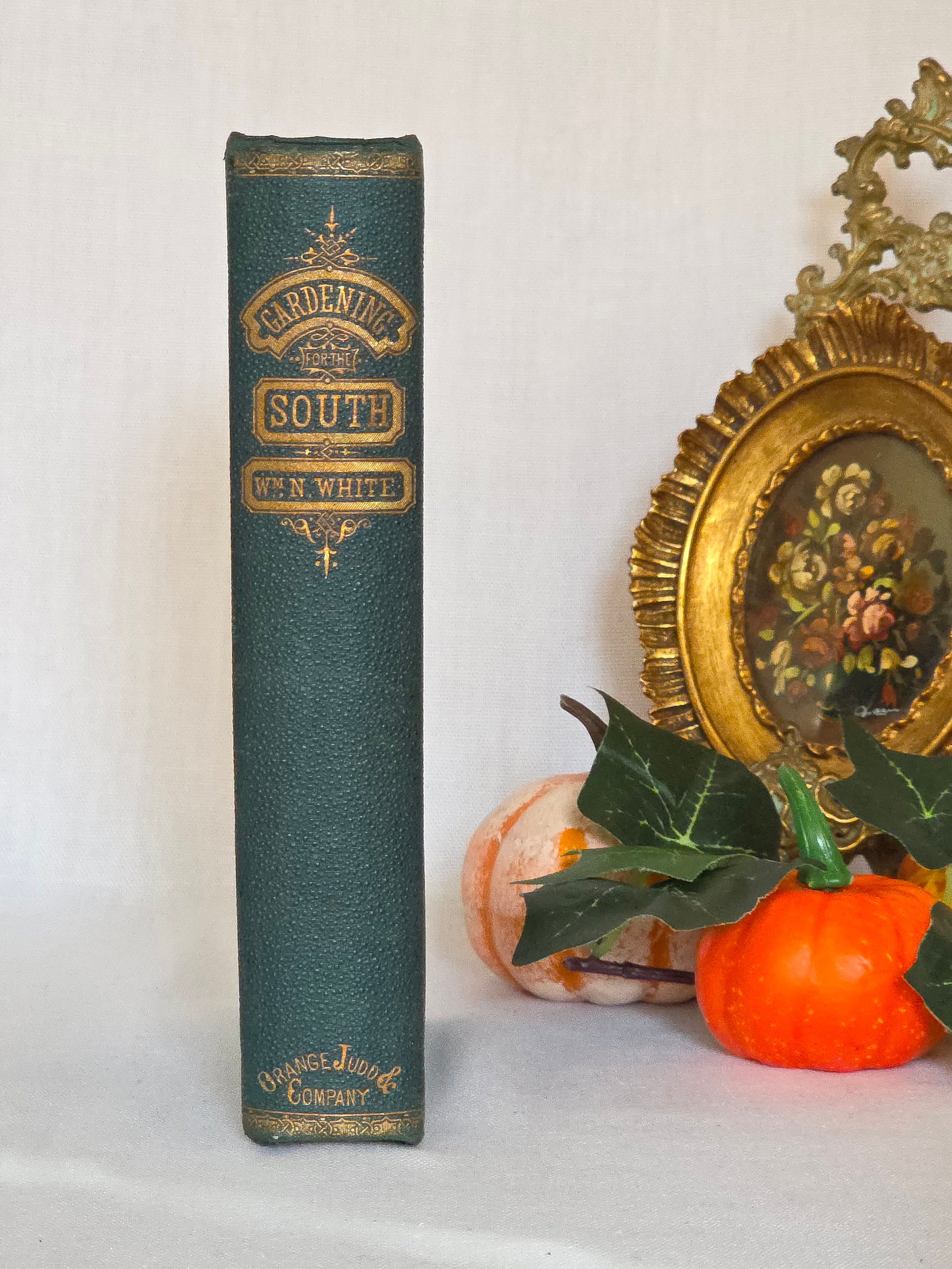 Antique book showing spine in green cloth with gilt decoration and titles saying 'Gardening For the South'