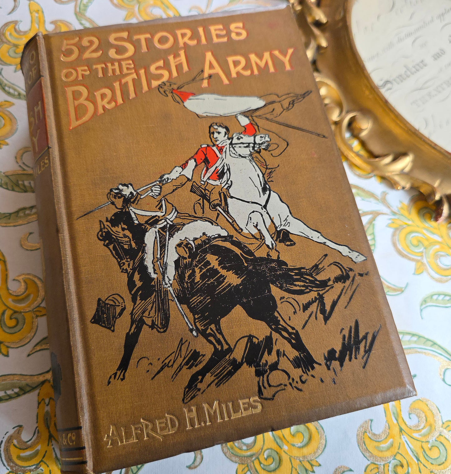 Antique book titled '52 Stories of the British Army' by Alfred H. Miles with a decorative cover illustration on a light gray background.