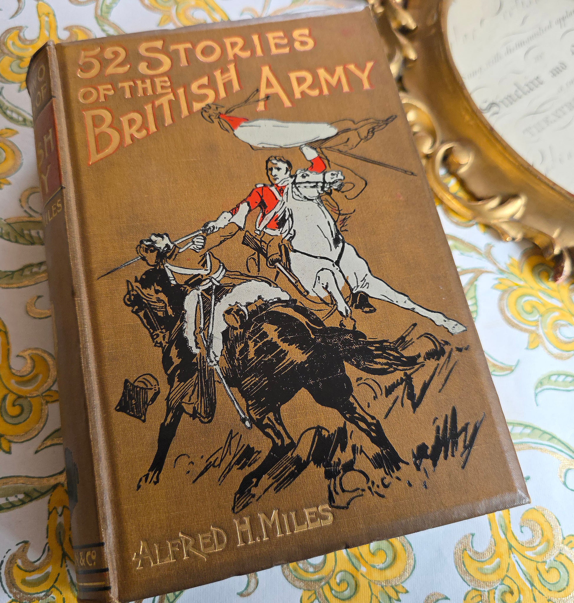Antique book titled '52 Stories of the British Army' by Alfred H. Miles with a decorative cover illustration on a light gray background.