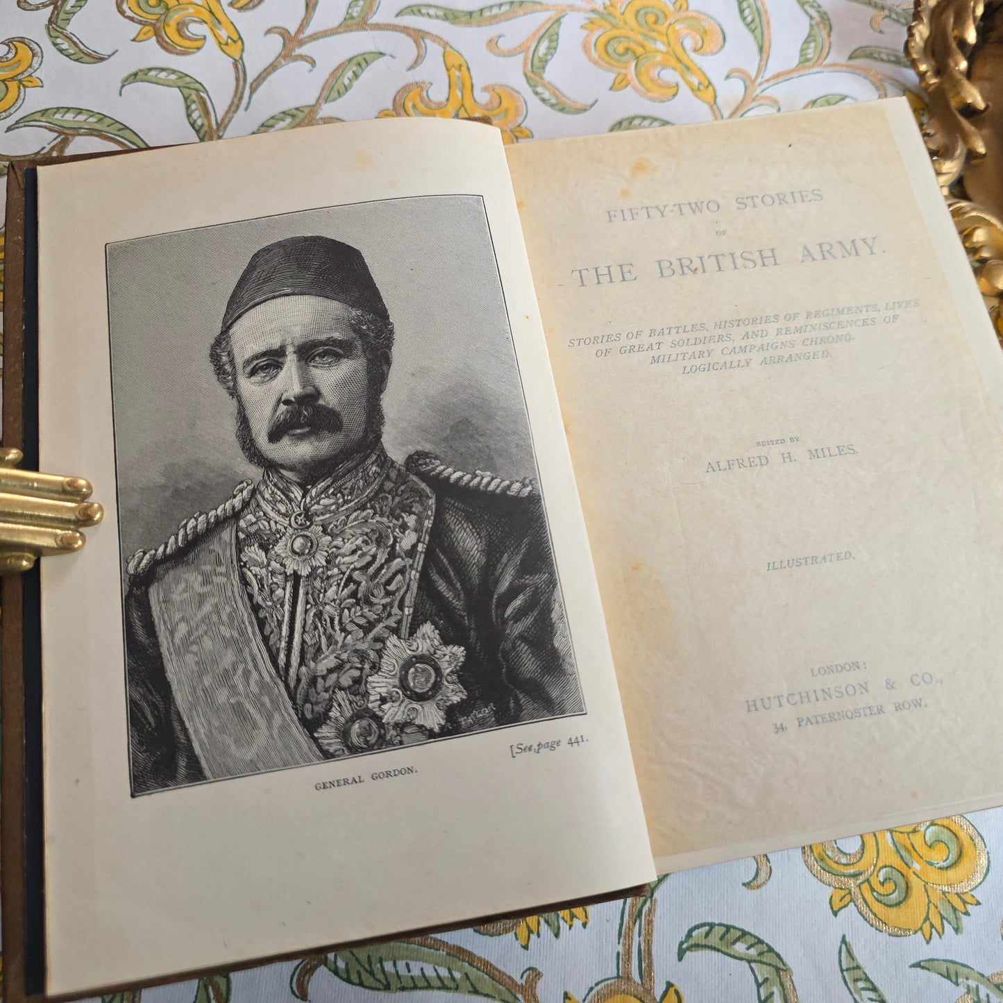 Antique book open showing title page and frontispiece of 52 Stories of the British Army, and portrait frontispiece 