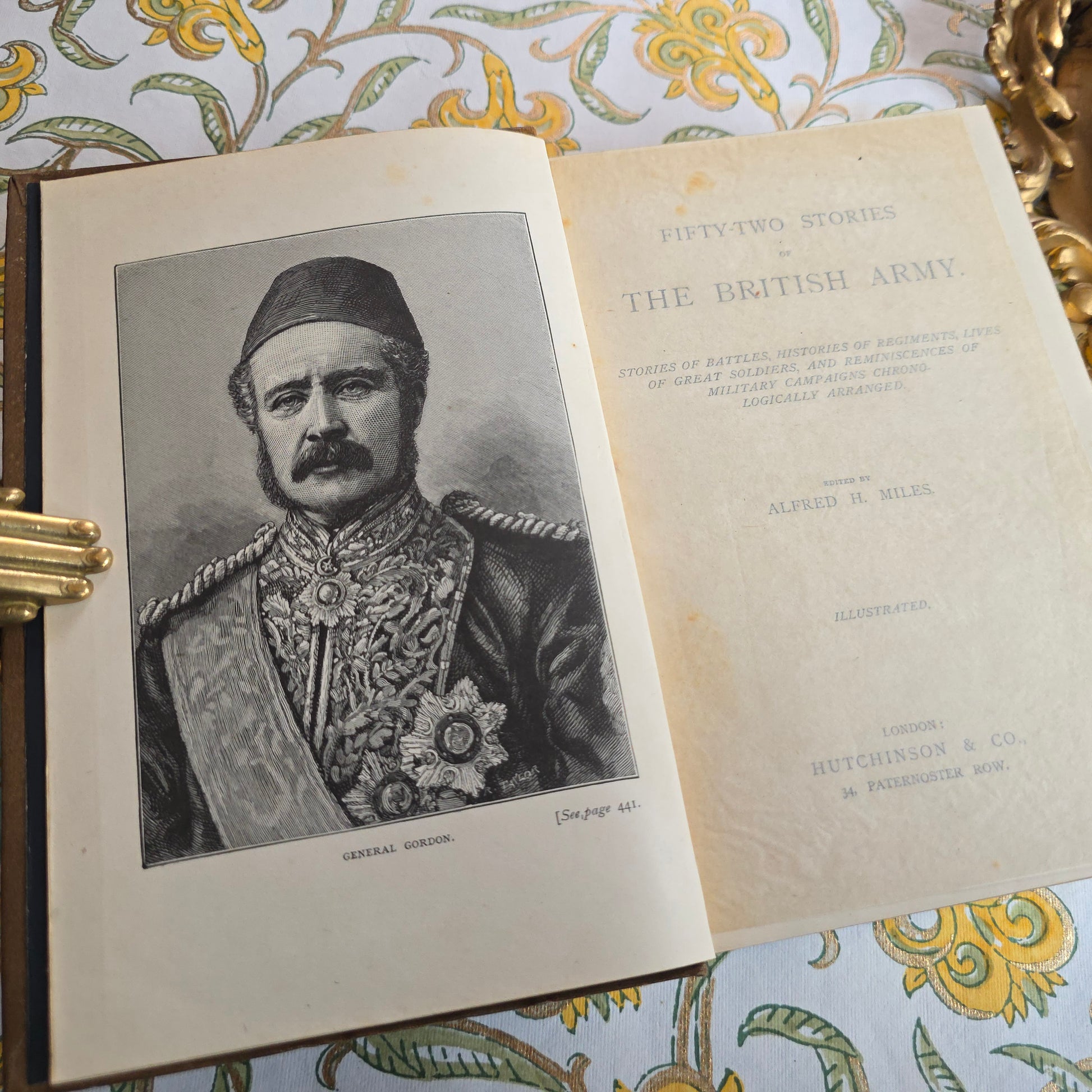 Antique book open showing title page and frontispiece of 52 Stories of the British Army, and portrait frontispiece 