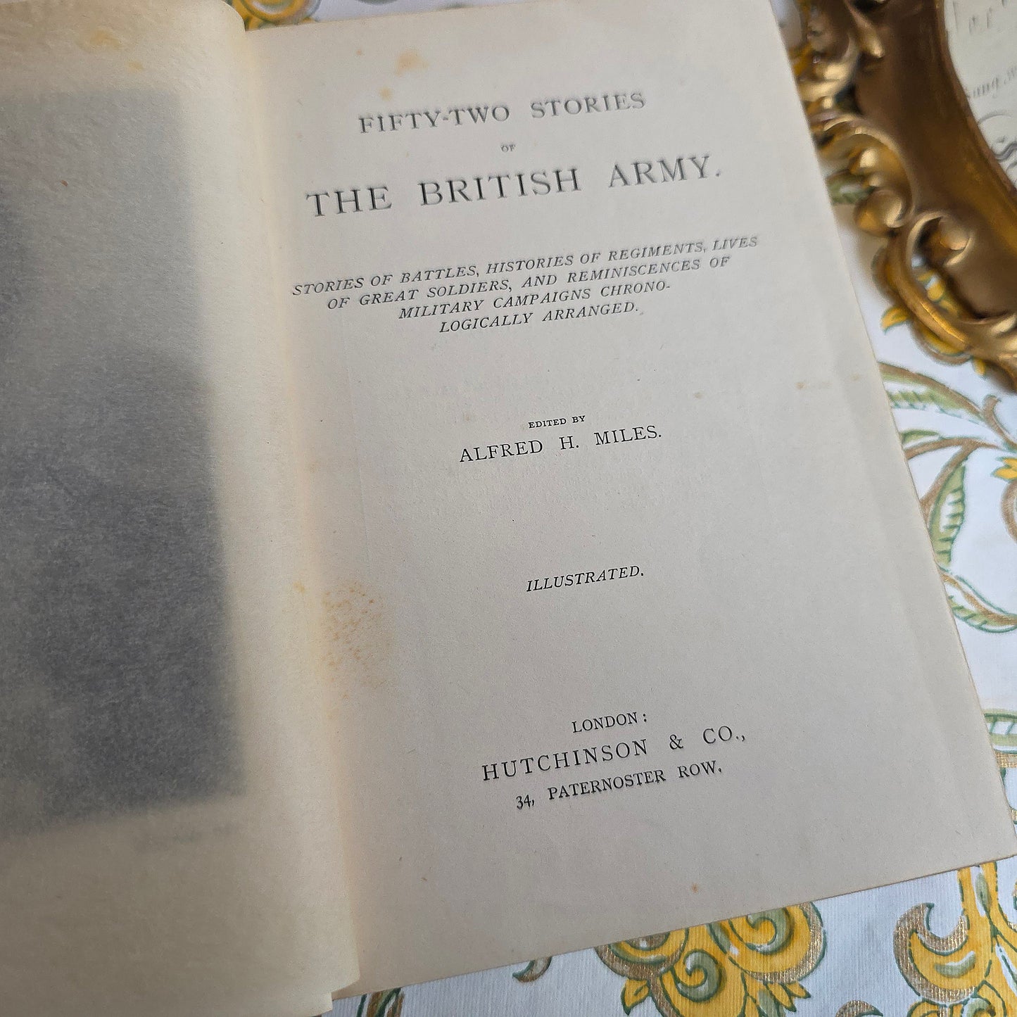 Antique book open showing title page and frontispiece of 52 Stories of the British Army