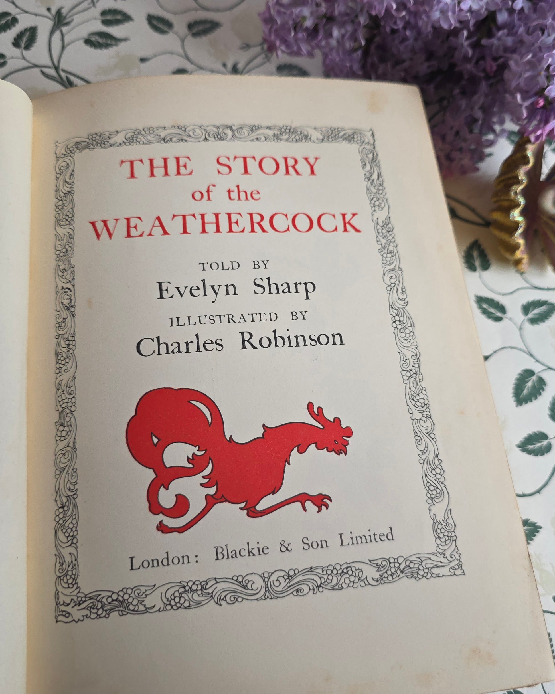 Antique book open showing title page of 'The Story of the Weathercock' by Evelyn Sharp