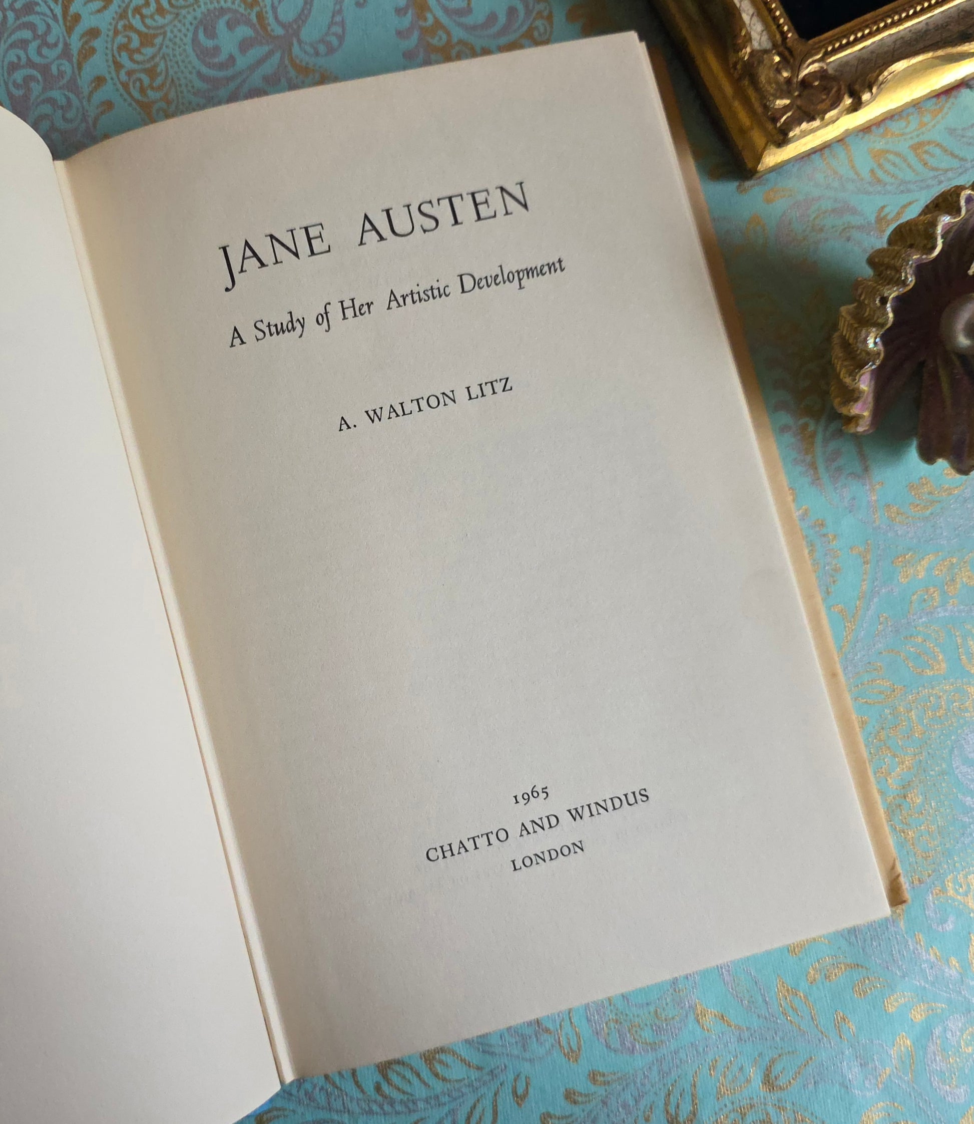 Book open at title page saying 'Jane Austen: A Study of Her Artistic Development' by A. Walton Litz on a decorative surface.
