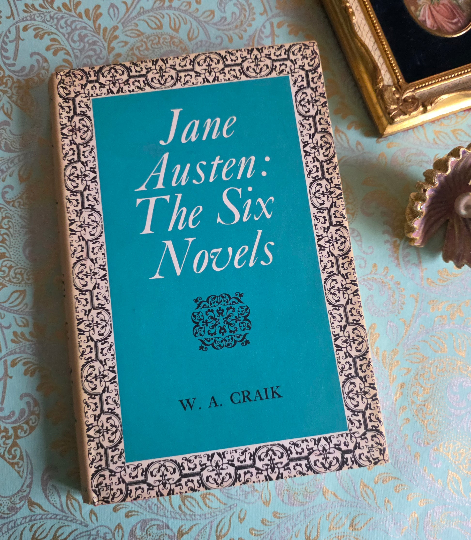 Book titled 'Jane Austen: The Six Novels' by W.A. Craik on a decorative surface.