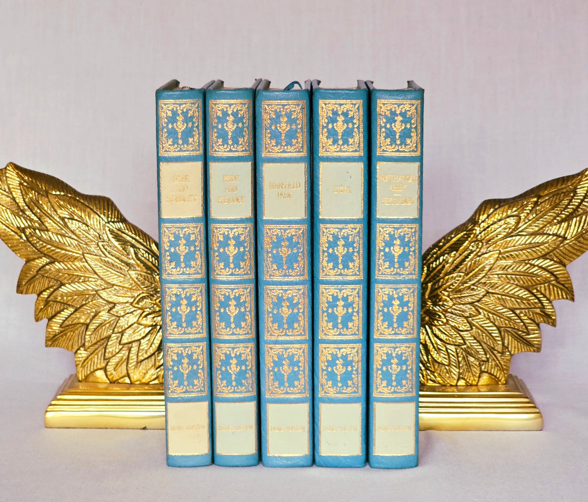 Set of five Jane Austen books in blue lambskin leather with ornate gilt decoration and white title plates